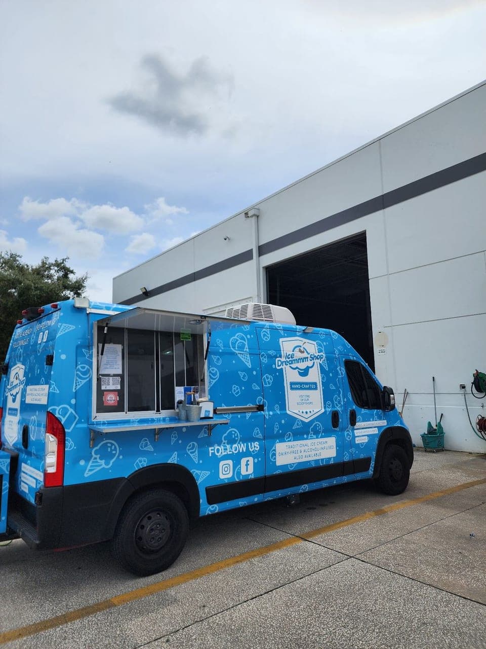 Ice cream truck with its serving window open, set up at a workplace
